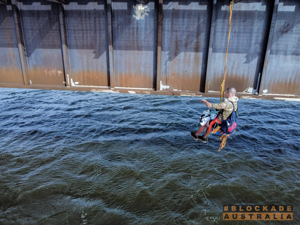 Abseiling activists hang off bridge Blockade Australia